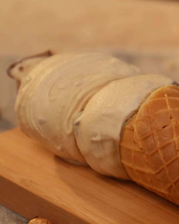 Cascão deitado sobre tábua, recheado de gelato de creme